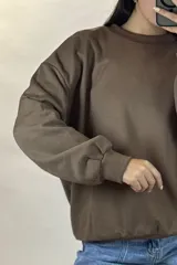 Buzo de cuello redondo, corte oversize, con mangas largas y puños elásticos.