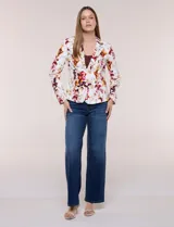 Blazer entallado de corte formal y estructurado, confeccionado en algodón con elastano. Presenta solapa clásica, cierre frontal con un botón a tono, bolsillos falsos tipo ojal en la cintura y mangas largas de corte recto. Cuenta con un diseño estampado floral en tonos rojo, bordó y amarillo sobre base blanca.