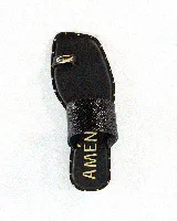 Sandalia plana de cuero color negro, con una tira ancha superior con textura, tira separadora de dedo con detalle metálico y suela con tachas doradas decorativas.