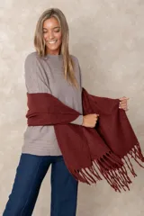 Pashmina de textura suave en color bordó, con diseño rectangular y terminaciones con flecos en los extremos.