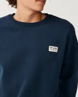 Buzo azul marino Rip Curl con cuello redondo, mangas largas y estampa trasera en color blanco con texto y logo de la marca.