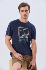 Remera azul marino de manga corta con cuello redondo y estampa frontal de un paisaje de playa con palmeras y el texto 'Legacy Beach Club'.