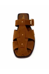 Zueco de gamuza negra con diseño trenzado tipo fisherman, hebilla metálica dorada y tachas decorativas.
