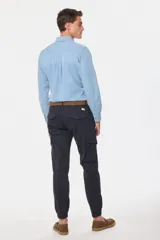 Pantalón cargo azul marino con bolsillos laterales con solapa y cinturón de cuero marrón.