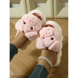 Pantuflas de peluche gris con diseño de chanchito, con suela de goma blanca y modelo abierto sin talón.