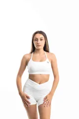 Top deportivo blanco con breteles finos y logo pequeño en el frente.