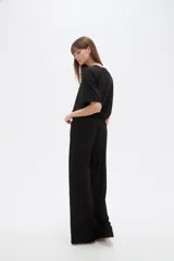 Pantalón ancho de tiro alto, color natural, confeccionado en poliéster con detalles de strass.