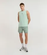 Bermuda deportiva para hombre, color verde menta, con short de compresión integrado. La bermuda exterior es suelta y tiene un pequeño logo estampado en el muslo izquierdo.