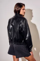 Campera bomber de cuero sintético negro, de corte oversize, con cuello solapa, cierre frontal metálico y bolsillos frontales con solapa.