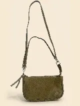 Cartera pequeña tipo bandolera confeccionada en gamuza color marrón oscuro, con cierre superior metálico y correa ajustable con herrajes plateados. Presenta un detalle de logo grabado en la parte inferior.