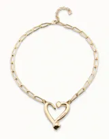 Collar dorado con cadena de eslabones alargados y dije central con forma de corazón estilizado, con la inscripción "UND & 50" en la parte inferior.