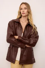 Chaquetón de cuero negro oversized, con corte recto y bolsillos delanteros. Presenta un bordado en los bolsillos inspirado en la costa atlántica.