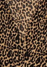 Vestido largo de corte recto con estampado de leopardo. Presenta escote en pico, mangas largas con puños elásticos y un diseño fluido sin cierre.