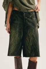 Bermuda de denim verde militar con efecto craquelado, corte culotte, tiro medio y ruedo deshilachado por debajo de la rodilla.