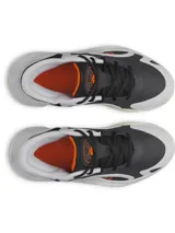 Championes de básquet Under Armour modelo UA GS Jet 25, con parte superior de materiales mixtos en tonos gris, negro y blanco, entresuela Micro G® y suela exterior de goma con detalles en naranja.