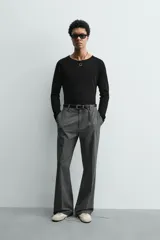 Camiseta negra de corte relaxed fit, confeccionada en tejido ligero con algodón. Presenta cuello redondo y manga ranglán larga.