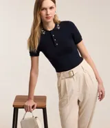 Pantalón zanahoria de mujer confeccionado en tela airflow color azul marino, con trabillas en la cintura, cinturón con hebilla, pliegues y elástico en la espalda.