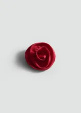 Accesorio para el pelo con forma de flor roja de tela satinada.