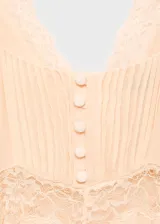 Vestido midi de estilo lencero en color crema, con escote en pico y detalles de encaje en el pecho y la cintura. Presenta tirantes finos ajustables y un diseño evasé con caída fluida.