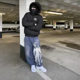Campera puffer blanca con capucha desmontable con borde de piel sintética gris, cierre frontal, bolsillos con cierre y detalles estampados en el pecho.