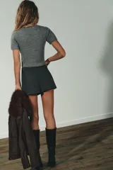 Jersey de punto suave con cuello subido y manga corta, con acabados en vuelta en los bordes.