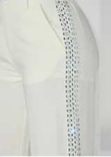 Pantalón sastrero de corte recto y cintura media con elástico en la parte posterior. Presenta una banda lateral decorativa con pedrería brillante a lo largo de ambas piernas, bolsillos laterales y cierre frontal con botón.