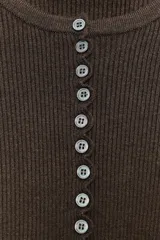 Chaqueta ajustada de punto acanalado color marrón oscuro, con cuello redondo y manga larga. Presenta un cierre frontal completo con botones pequeños y blancos. Los bordes del ruedo y los puños tienen un acabado festoneado.