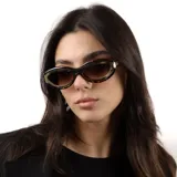 Lentes de sol con armazón de diseño ovalado y estilo cat-eye, con estampado carey y detalles metálicos dorados en los laterales. Cuentan con protección UV400.