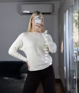 Sweater de punto con cuello redondo y mangas largas, con diseño de textura acanalada en los laterales y mangas. Presenta un corte holgado y cómodo.