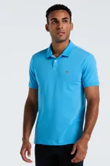 Chomba de piqué color celeste, con cuello clásico, cierre frontal de dos botones y logo bordado en el pecho.