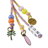 Llavero Rip Curl con tiras de cordón multicolor, mosquetón superior y múltiples dijes colgantes, incluyendo cuentas de colores, letras, una palmera y una tabla de surf.
