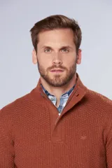 Buzo de tejido grueso color gris, con cuello alto y cierre frontal parcial. Presenta puños y ruedo acanalados, con un diseño de textura tejida en toda la prenda.