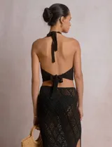 Top crop de tejido calado beige, con escote halter y patrón geométrico de rombos.