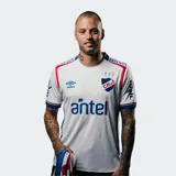 Camiseta de fútbol Umbro del Club Nacional de Football, modelo Home 2025, para hombre. Diseño blanco con sutil patrón en relieve, cuello redondo con ribetes azules y rojos, y detalles en las mangas. Incluye escudo del club, logo Umbro y sponsor Antel en el frente.