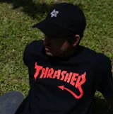 Remera negra de manga corta con el logo de Thrasher en rojo con cuernos y cola de diablo.