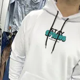 Canguro blanco oversize de algodón con felpa, con capucha y cordón ajustable. Estampa en la espalda con la frase "Stay Strong" en negro y turquesa, y texto inferior con la marca "Duxon Originals".