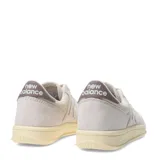 Championes urbanos New Balance modelo Court, color beige con detalles en crema y suela de goma con efecto envejecido. Presentan el logo N característico en los laterales y perforaciones en la puntera para mayor ventilación.