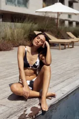 Conjunto de bikini marrón chocolate con tela acanalada. El corpiño es de triángulos fijos unidos por una argolla central y tiene breteles y lazo regulables en la espalda. La bombacha es vedetina con argollas de madera en las caderas.