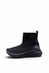 Bota tipo zapatilla de caña alta confeccionada en tejido de malla y material sintético, color beige, con suela robusta y diseño tipo slip-on.