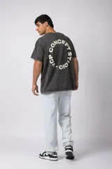 Remera oversize de algodón con efecto lavado gastado, cuello redondo y mangas cortas. Presenta un diseño circular estampado en el pecho con el texto VCP CONCEPT STUDIO.