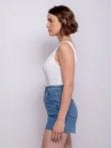 Short de jean negro con cuatro bolsillos, presillas, terminación desflecada, botón y cierre metálico.