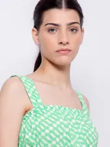 Top blanco con estampado floral en tonos naranja y lila, de corte cropped y breteles anchos.