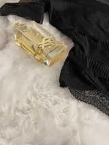 Body negro de terciopelo acanalado con detalles de microtul y encaje, cuello alto y espalda descubierta.