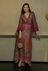 Vestido largo de gasa con estampado animal print en tonos rojizos y marrones, con escote en V y botones frontales. Presenta mangas largas abullonadas y un corte holgado.