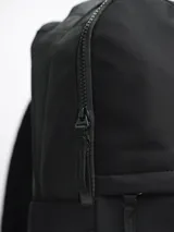 Mochila negra con dos compartimentos con cierre, asa de mano y tirantes acolchados ajustables. Logo de la marca en la parte inferior.