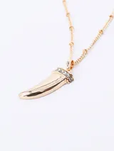 Collar dorado con dije en forma de colmillo con incrustaciones de strass en la parte superior.