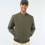 Campera estilo bomber color verde militar, con cierre frontal, cuello, puños y ruedo de tejido elástico acanalado. Presenta un bolsillo con cierre en la manga izquierda.