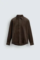 Camisa de corte relajado confeccionada en pana de algodón, con cuello solapa, manga larga con puños abotonados y cierre frontal de botones.