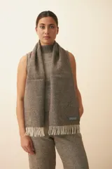 Bufanda unisex color marrón con flecos en los extremos.