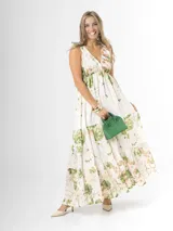 Vestido largo confeccionado en mezcla de tencel y lino, con fondo off white y estampado floral en tonos rosados, rojos y verdes. Cuenta con escote en V pronunciado, breteles anchos ajustables con lazos en los hombros, corte bajo el busto y falda amplia con volados escalonados.